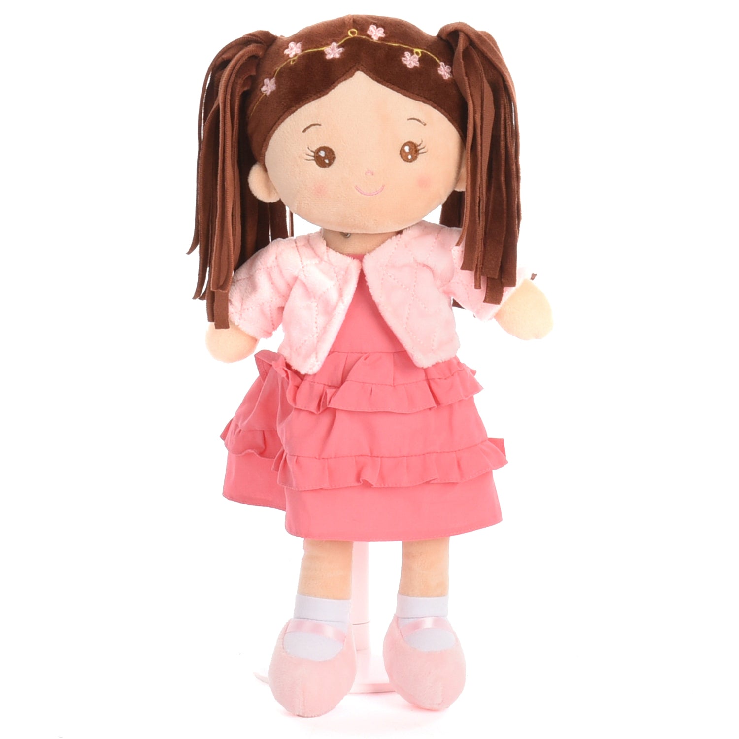 A plush doll with brown pigtails, wearing a pink dress, pink jacket, and pink shoes, standing against a plain white background.