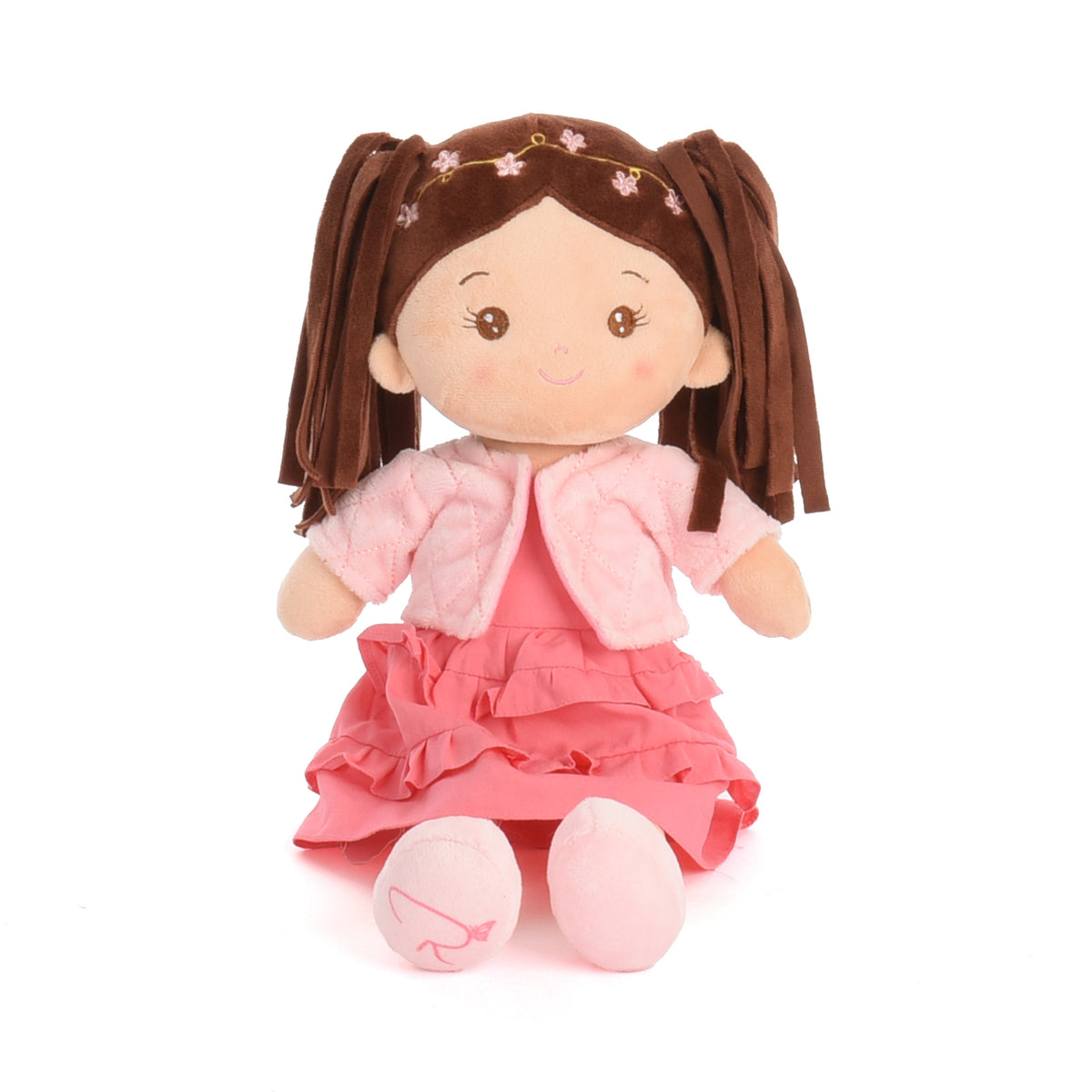 A plush doll with brown pigtails, a pink ruffled dress, and a light pink jacket, seated against a plain white background.